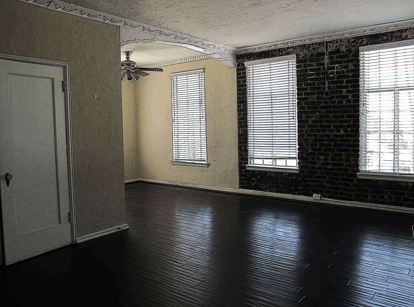 An empty apartment living room with dark floorboards